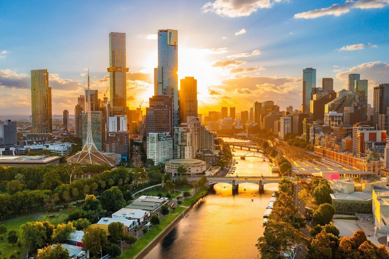 Melbourne from above at sunrise, the Yarra river running past the city towers
