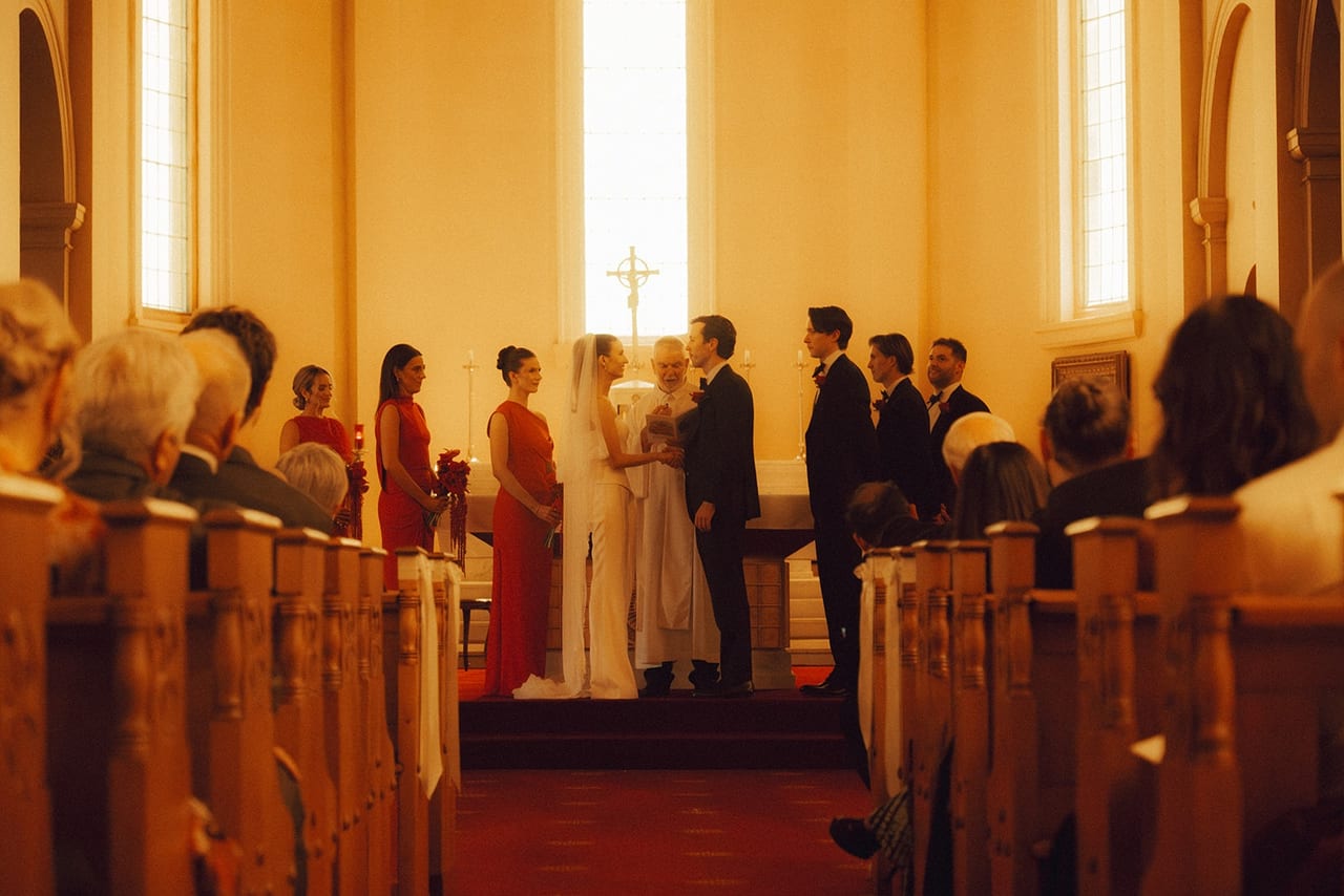 A church ceremony seen from the pews in warm afternoon light