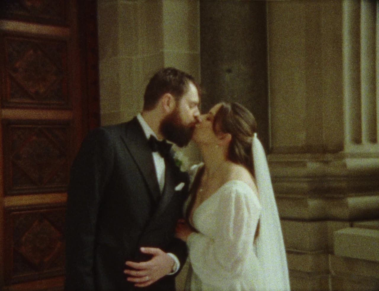 A kiss in front of the carved wooden door of the church