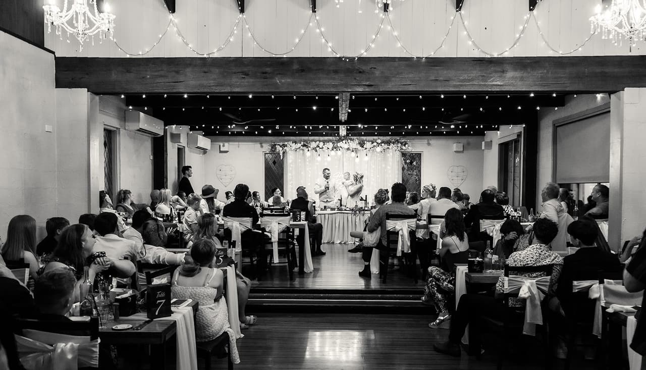 Black and white wide view of the reception hall during the speeches