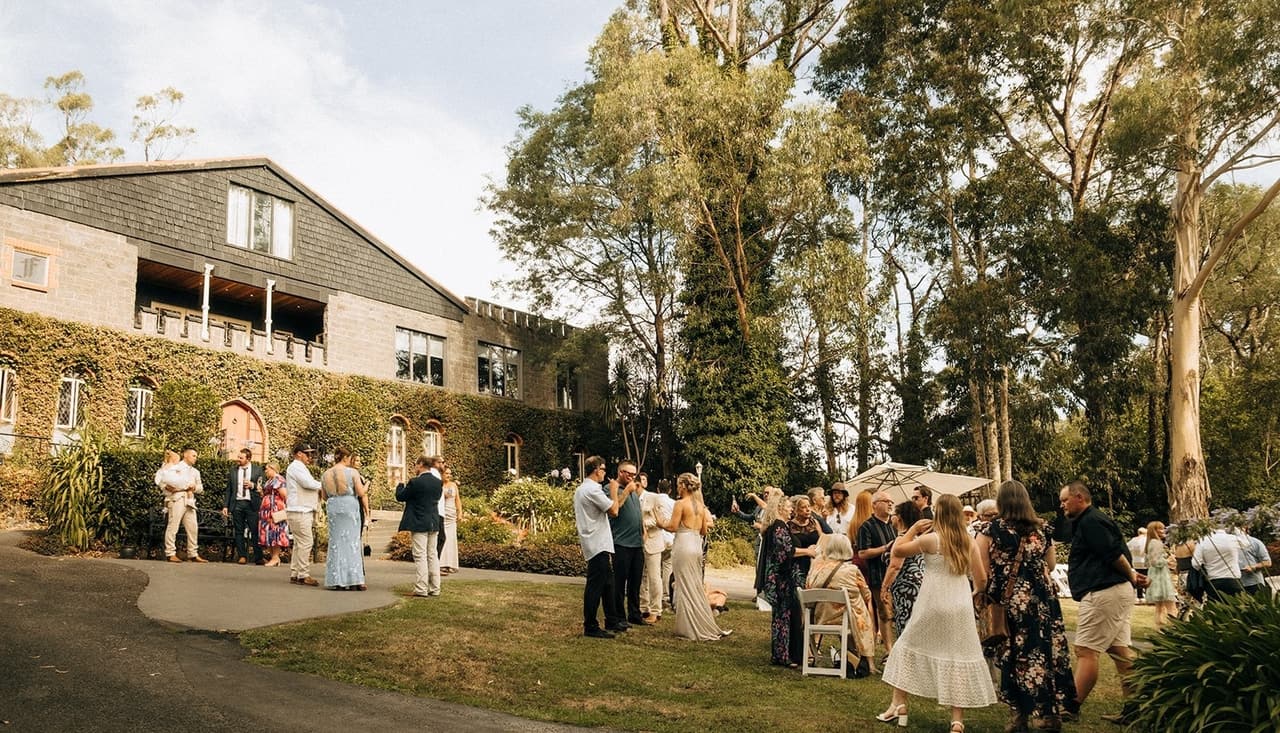 Guests mingling on the lawn in front of the castle after the ceremony