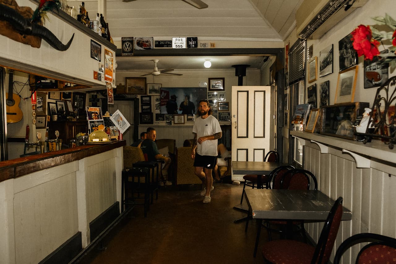 Inside the old pub, a long bar on one side and the walls covered in photos and memorabilia