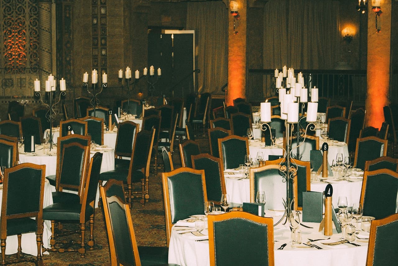 Tall candelabras and green velvet chairs on the ballroom tables