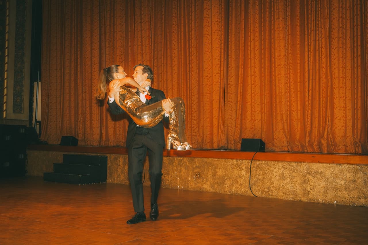 Nick lifting Kira during the first dance in front of the stage curtain