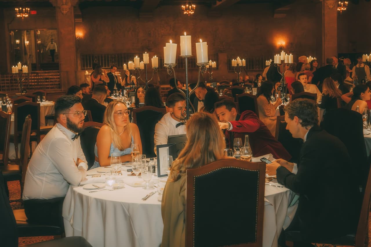 Guests at round candlelit tables during dinner
