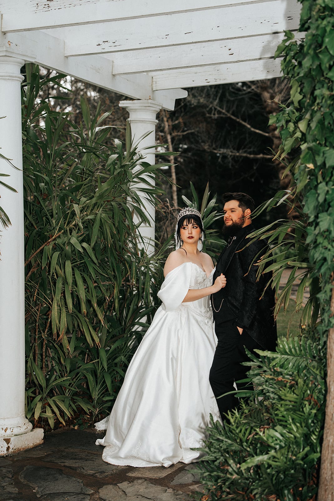 Porscha and Jordan under the white pergola, framed by the garden’s greenery