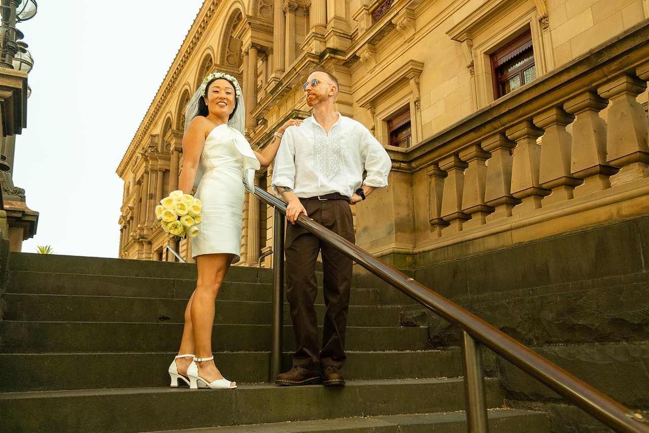 Cecile and Stefan on the long flight of sandstone steps beside the Old Treasury Building, its arched windows above them