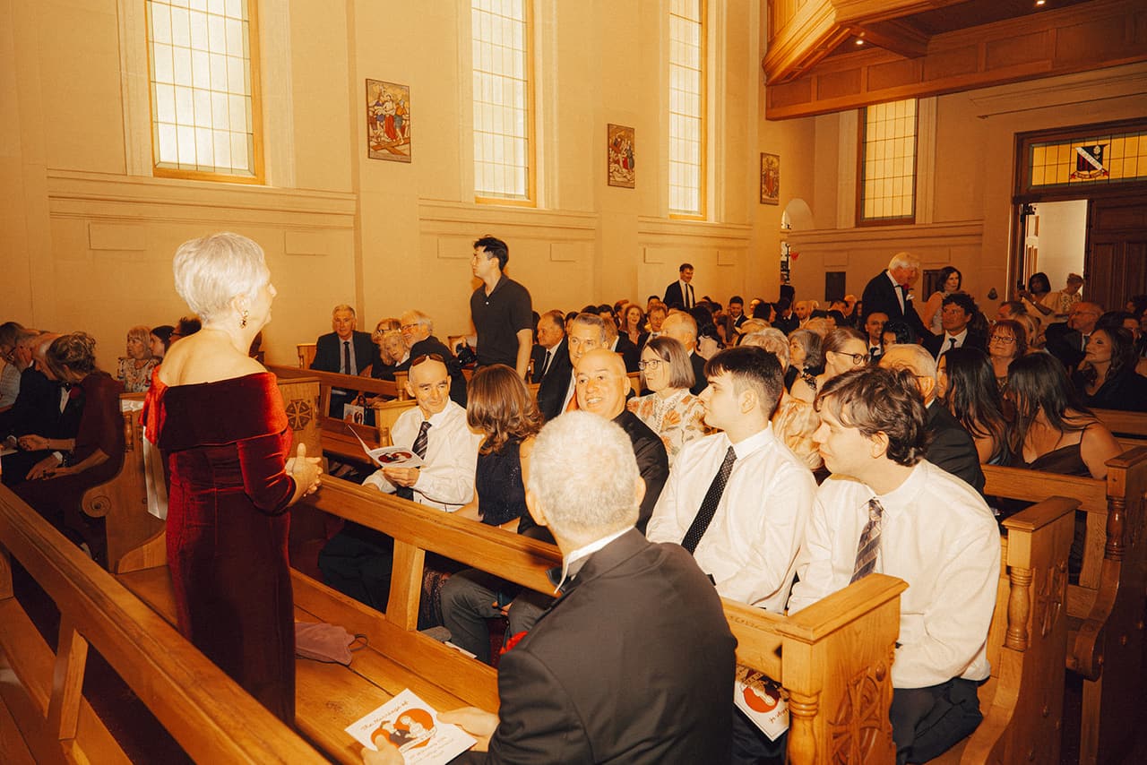 Guests filling the timber pews under the tall chapel windows before the ceremony
