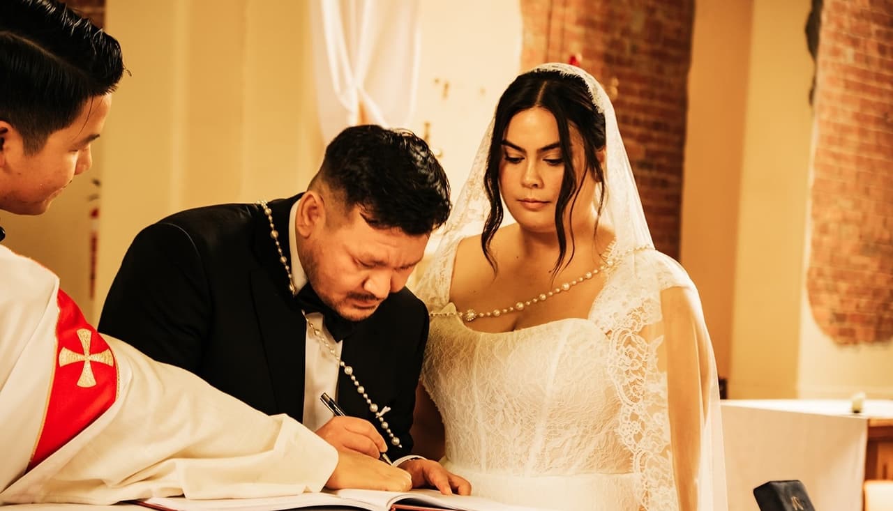 Bryan signing the register at the altar table with Ashley beside him