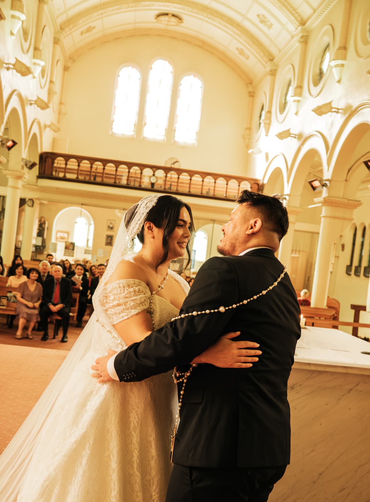 Ashley and Bryan hugging after the kiss, the rosary cord still looped around them