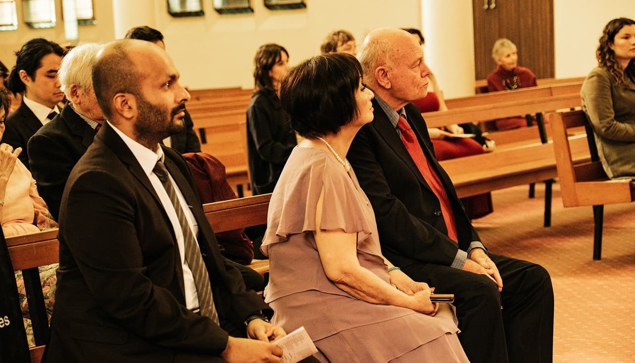 Family in the front pews listening during the ceremony