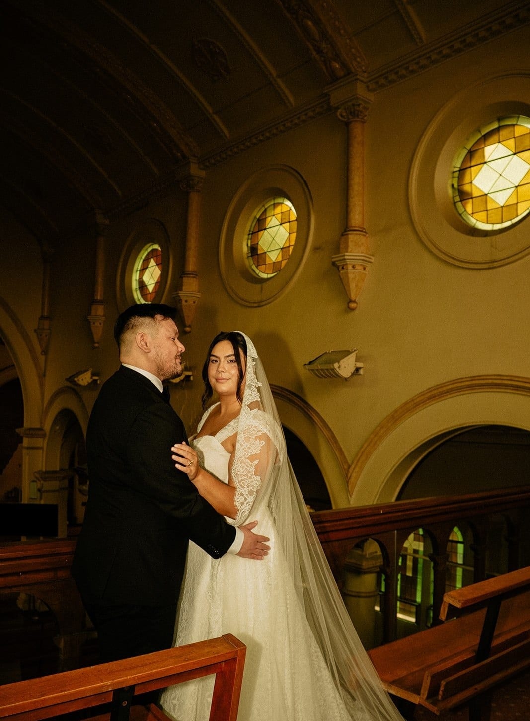Ashley and Bryan in the choir gallery, the church’s round windows lit behind them