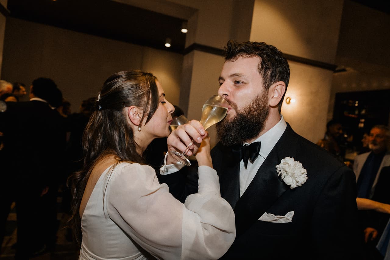 Bianca and Aidan sipping champagne together at the reception