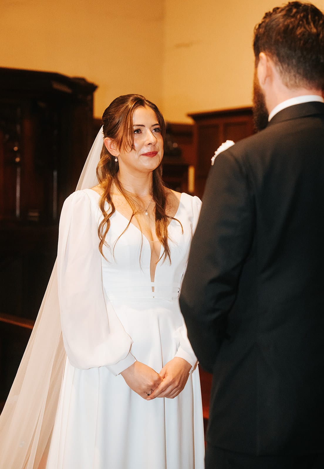 Bianca smiling up at Aidan at the altar of St Peter's Eastern Hill