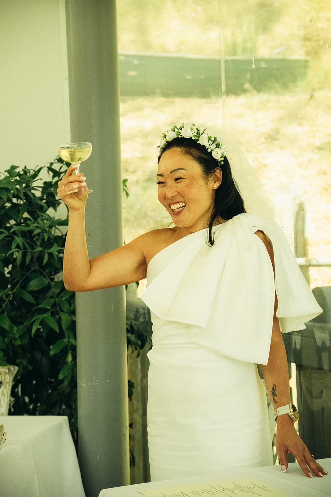 Cecile raising her glass and laughing during the speeches on the verandah
