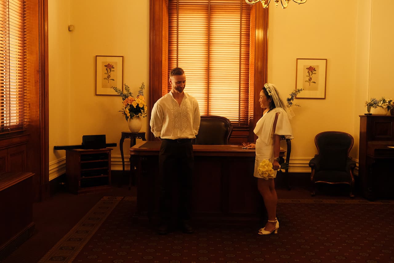 Cecile and Stefan facing each other in the warm timber room of the marriage registry