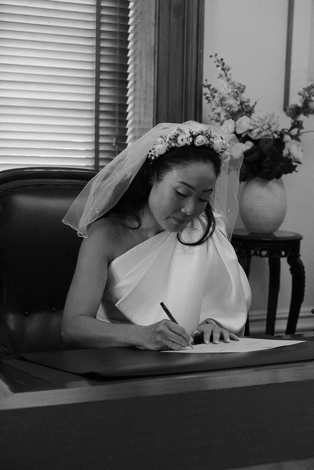 Black and white photo of Cecile signing the register