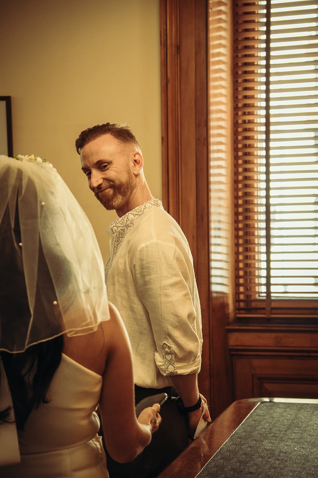 Stefan smiling at Cecile beside the tall shuttered window, the edge of her veil in the foreground