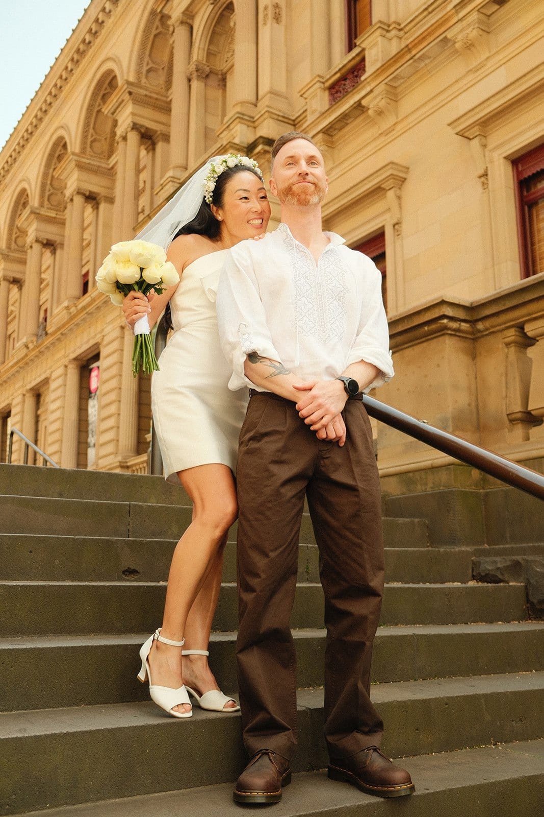 Cecile leaning back against Stefan on the stone steps