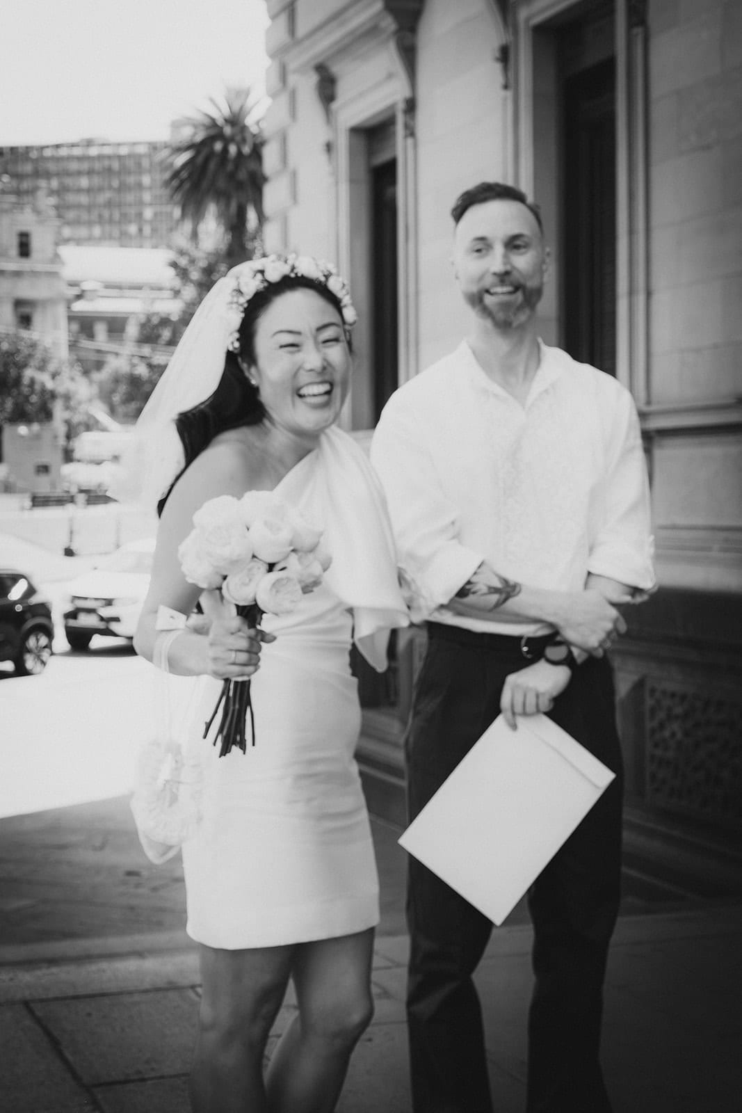 Black and white photo of Cecile and Stefan laughing outside the Old Treasury Building
