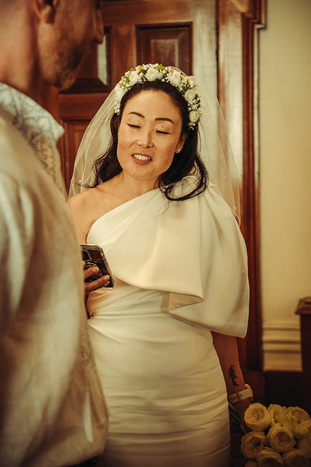 Cecile smiling as she reads her vows from her phone
