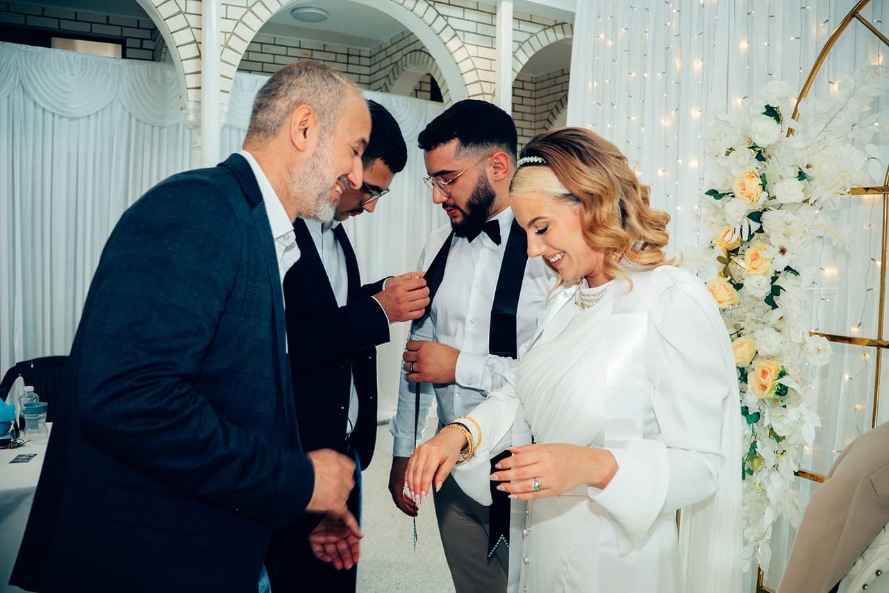 Relatives pinning gold onto Elektra and Yasir at the reception