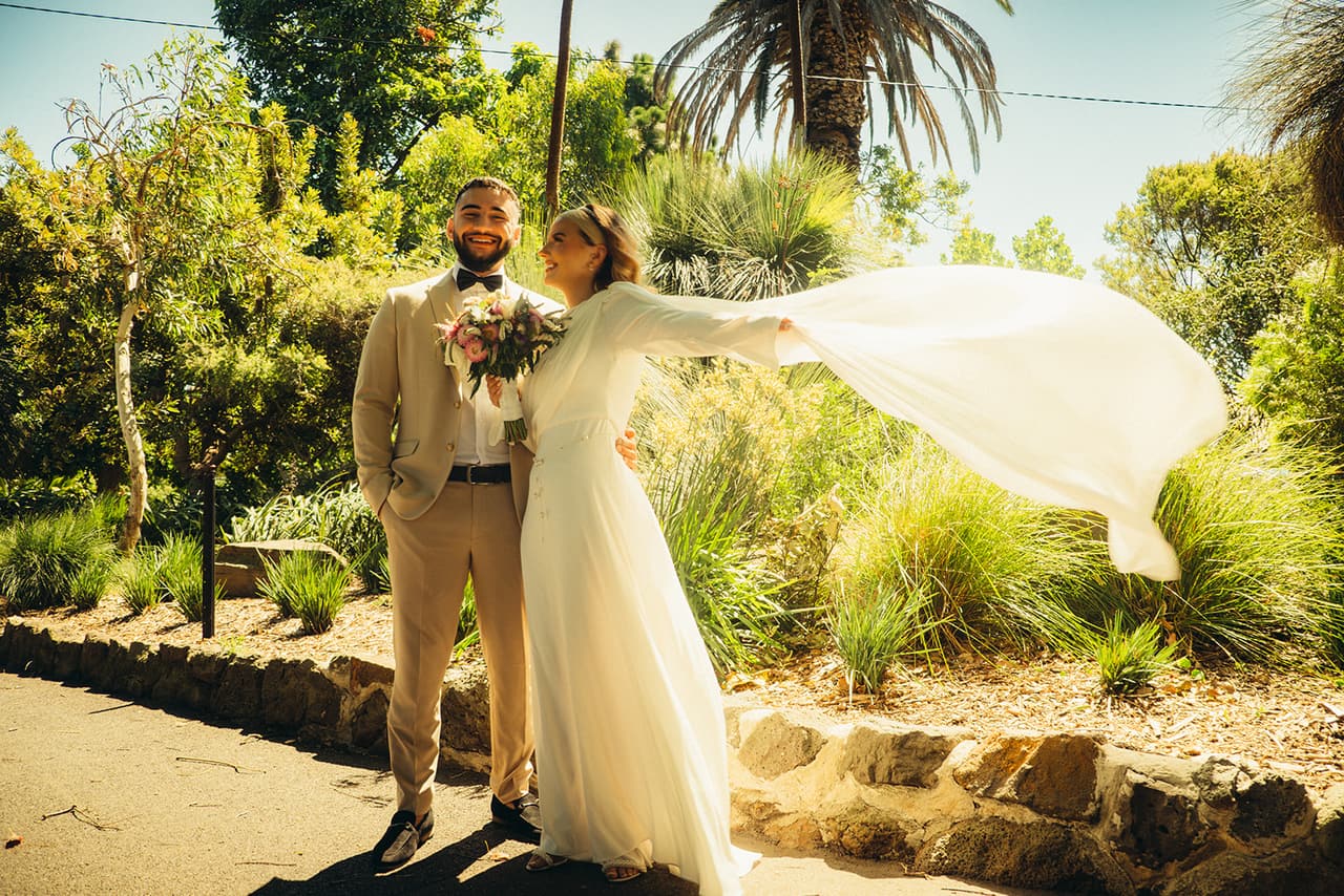 Elektra’s veil flying out in the breeze as she stands beside Yasir in the garden