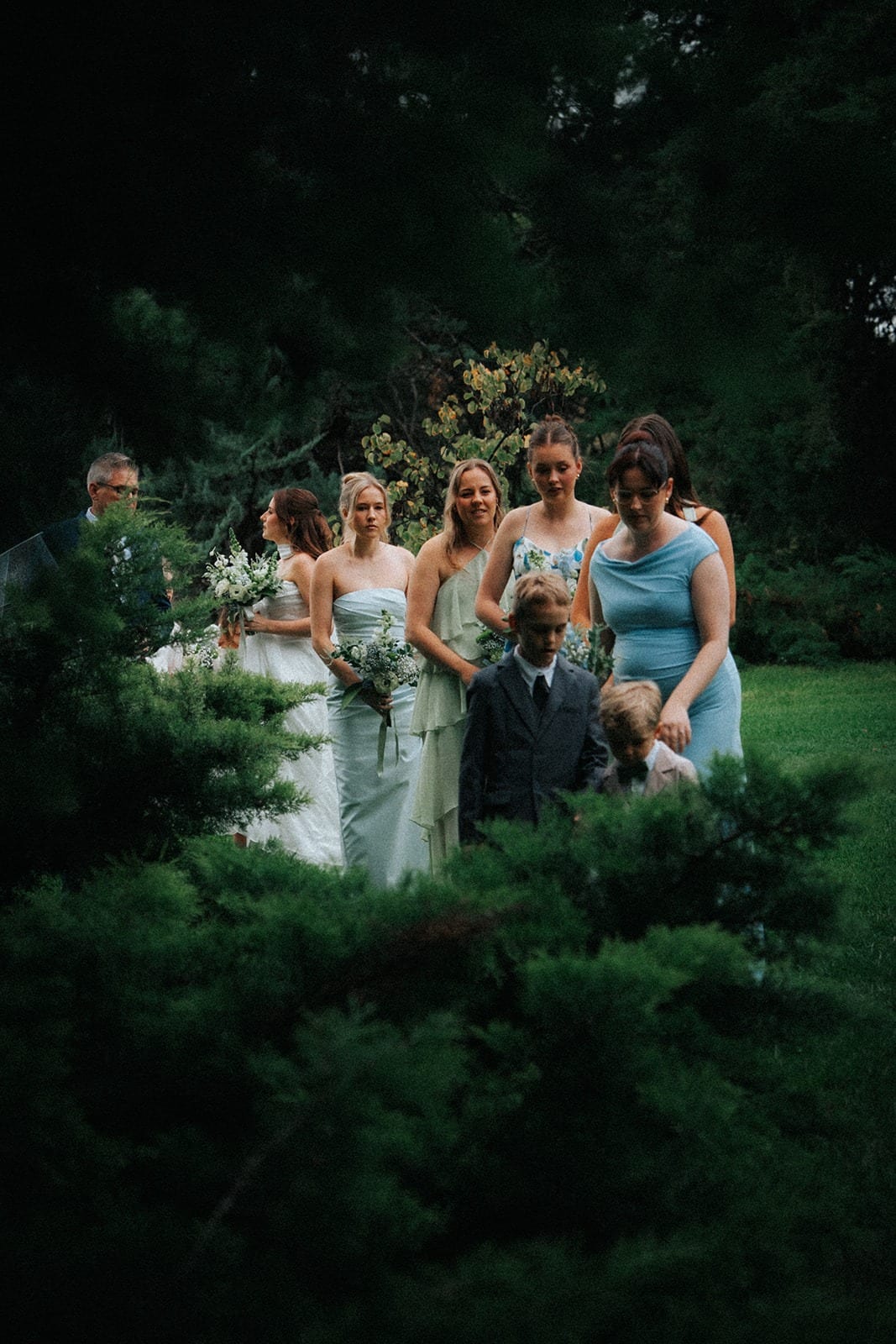 Bridesmaids gathered behind a hedge before walking down the aisle
