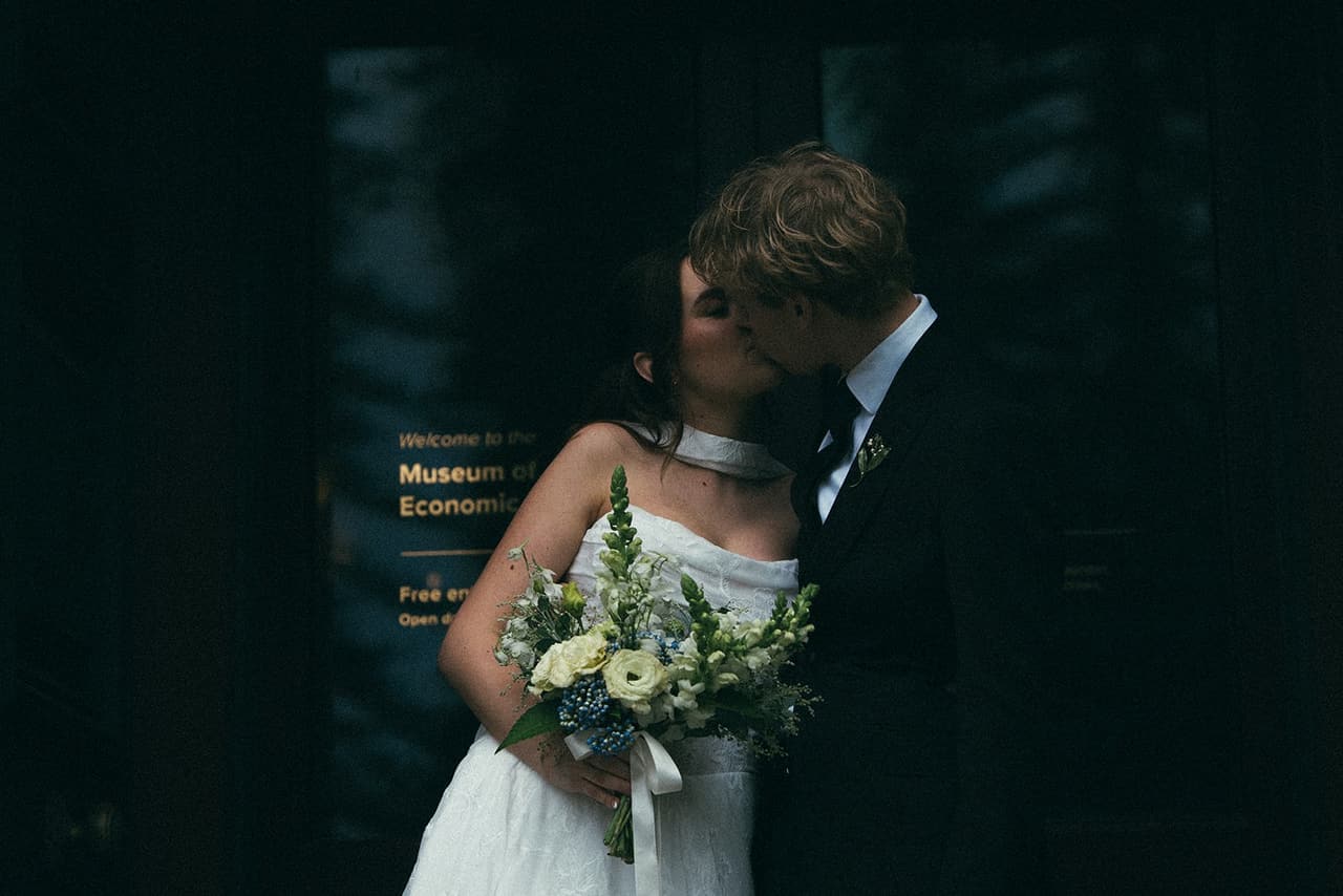 Eli and Charlotte kissing in the doorway of the Museum of Economic Botany
