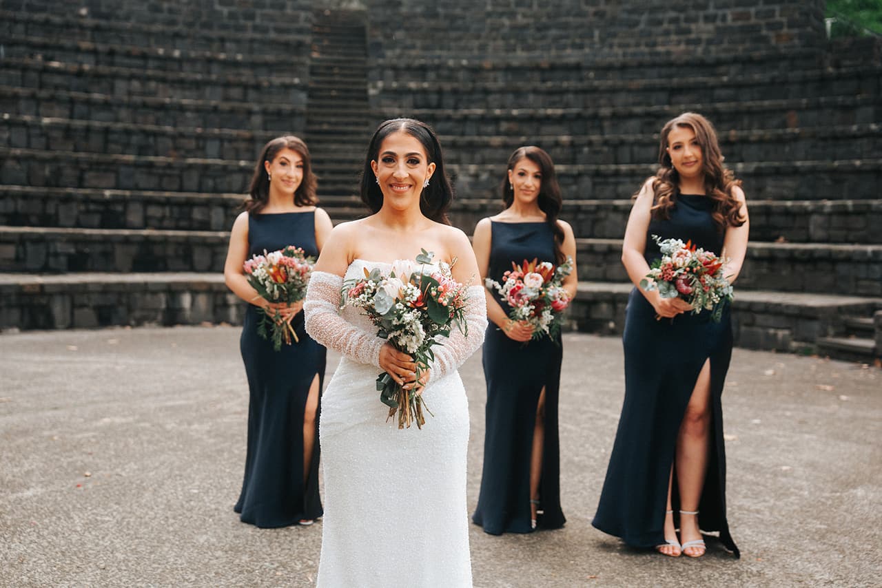 Tia with her bridesmaids in navy on the stone terraces of the Fairfield Amphitheatre