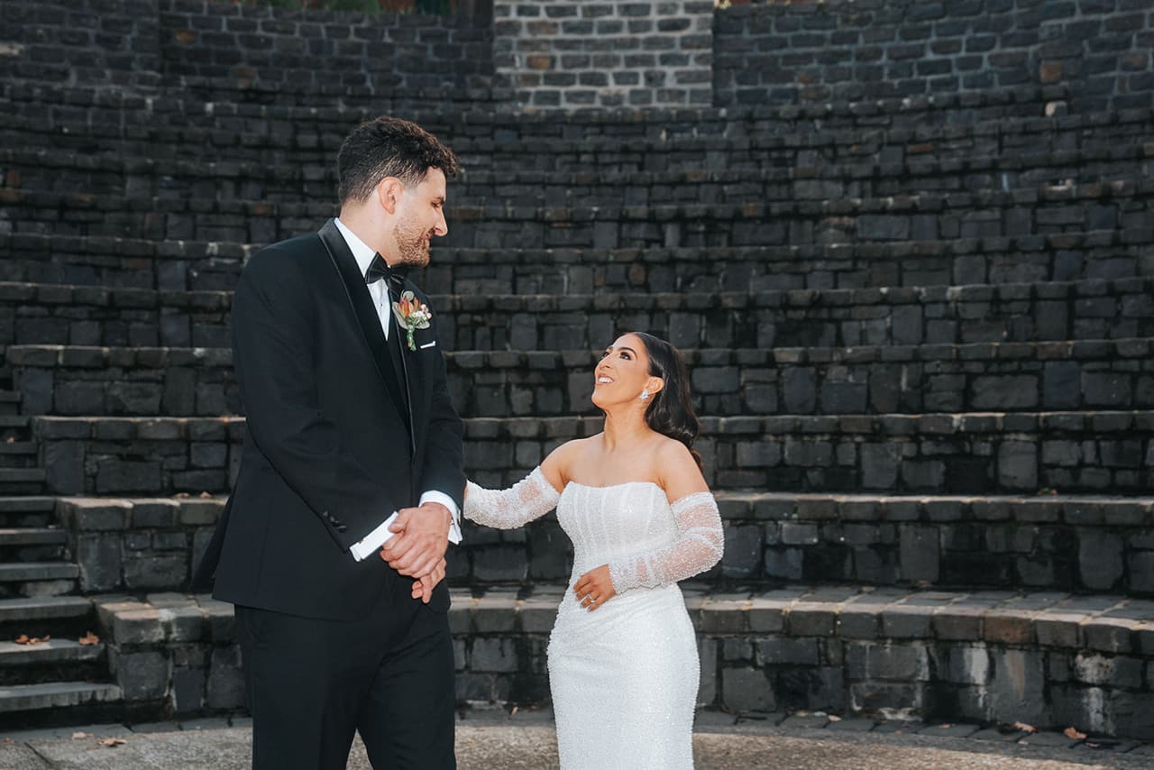 George turning to see Tia, both of them smiling in front of the stone terraces