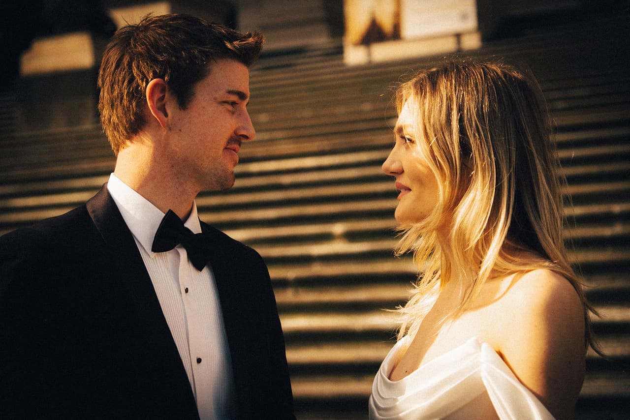 Hannah and Josh looking at each other at the foot of the Parliament House steps