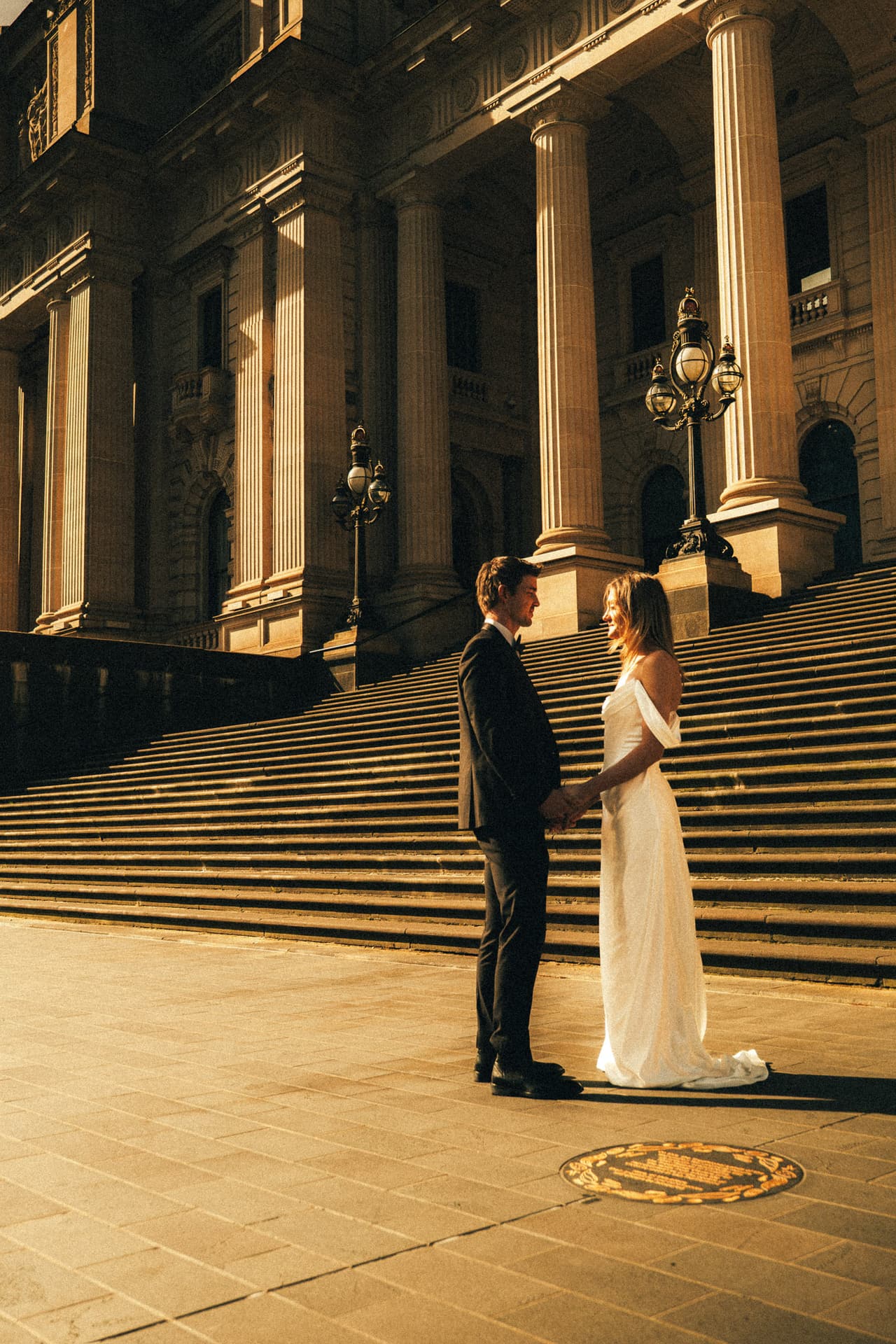 Hannah and Josh at the foot of the sunlit Parliament House steps