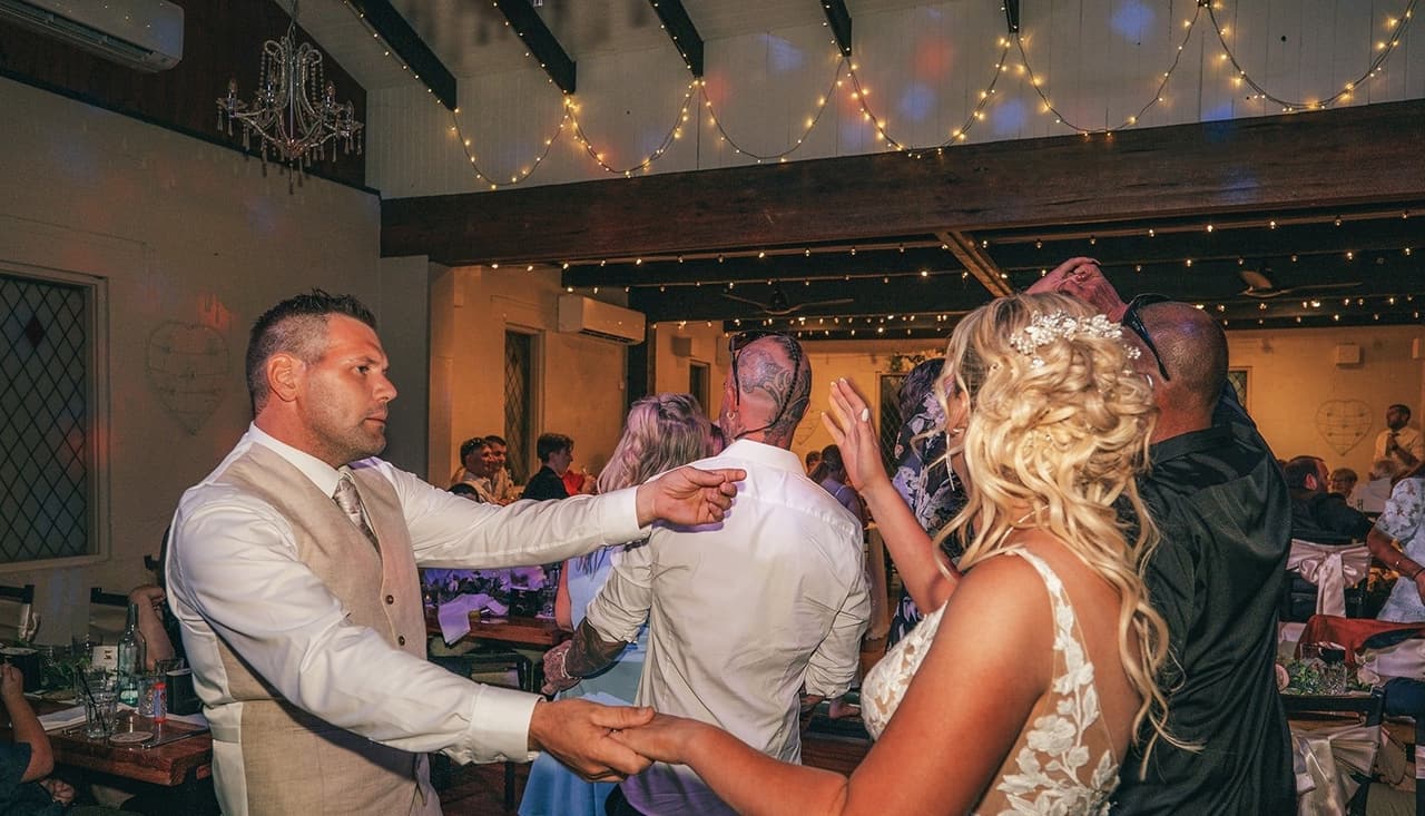 Jenna and Nick dancing with their guests in the reception hall