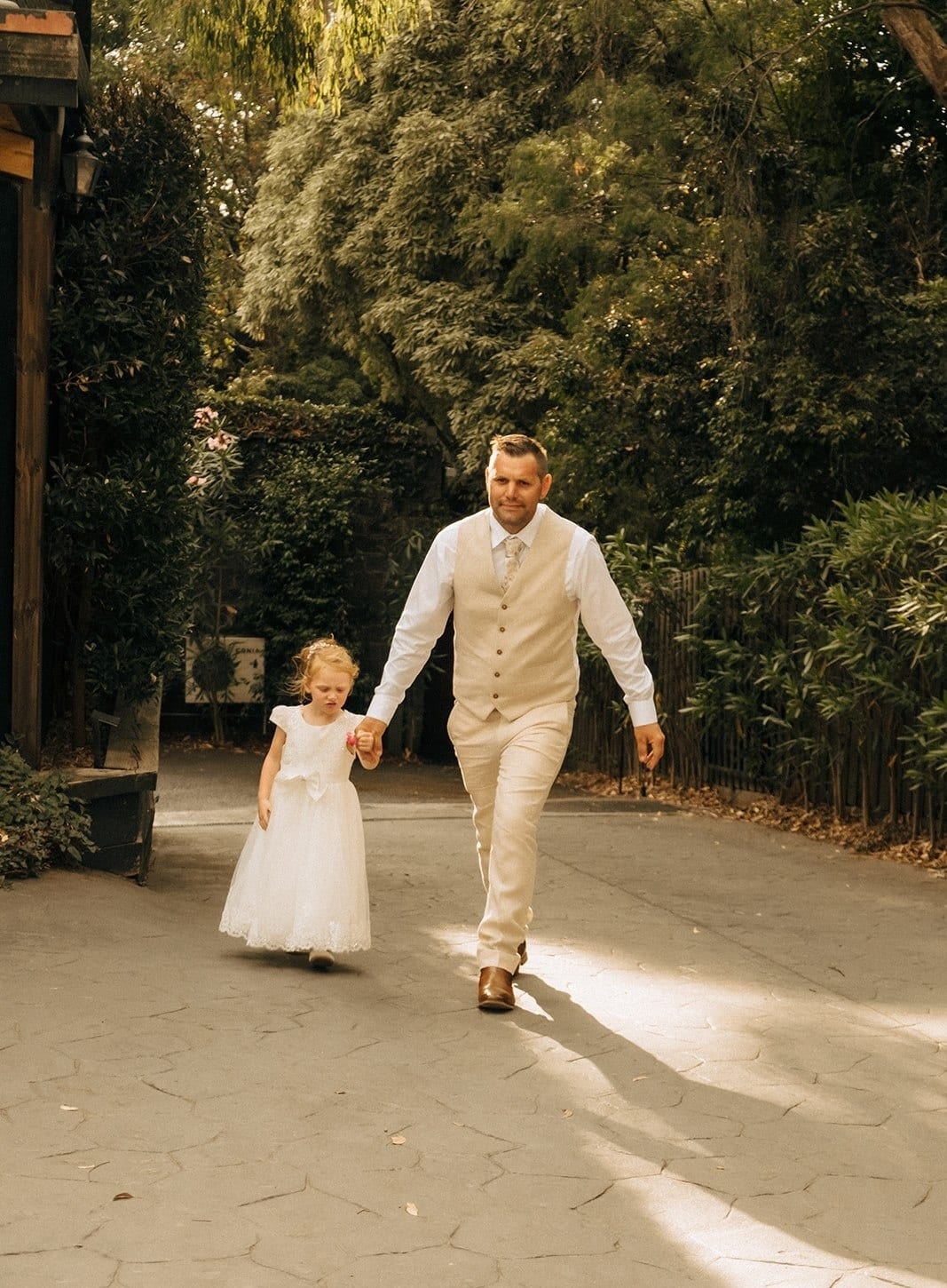 Nick and a flower girl walking along the castle driveway