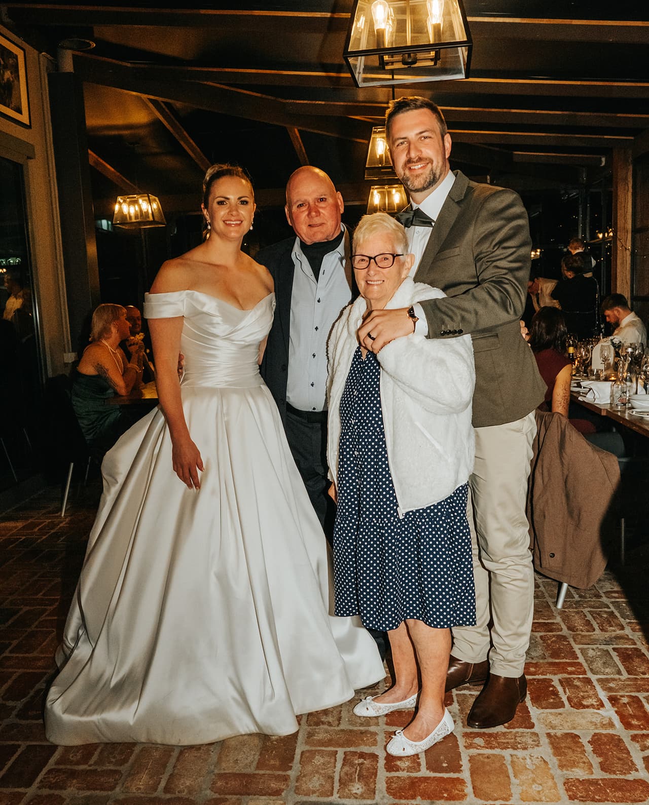 Jessica and Max with an older woman in a polka dot dress and white cardigan, her arm through Max’s