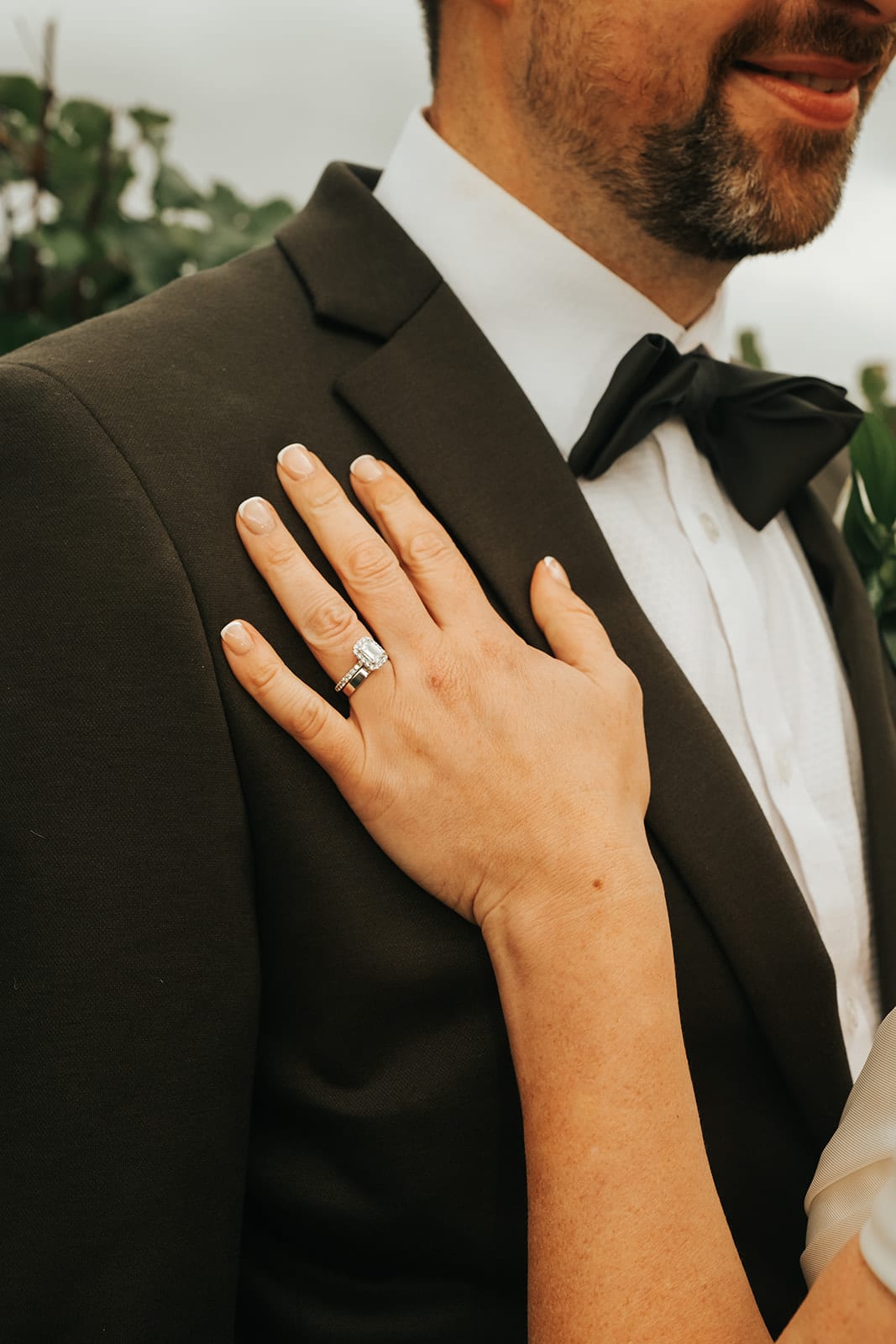 Jessica’s hand and new rings resting on Max’s lapel