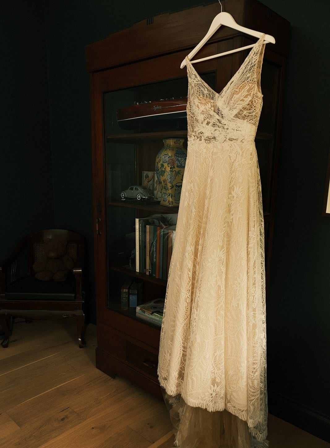 Joanna’s lace wedding dress hanging in a dark timber doorway