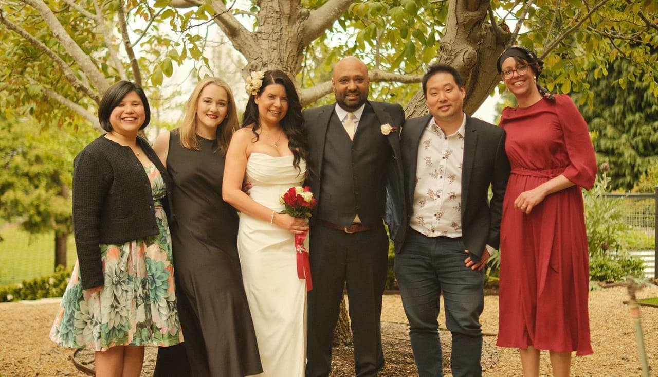 Joanna and Krish with their guests under the tree on the gravel