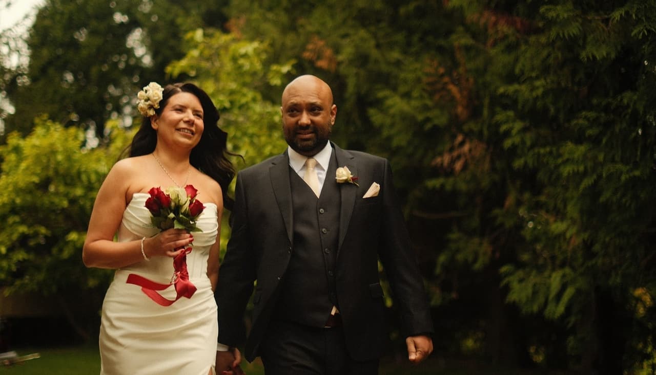 Joanna and Krish walking together through the trees, laughing