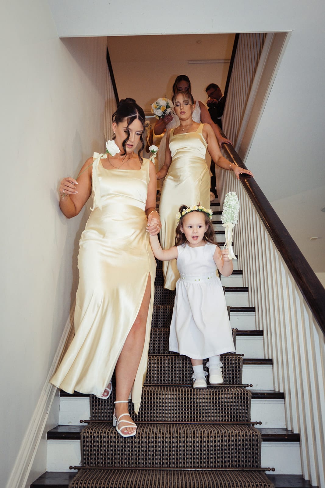 Bridesmaids and the flower girl coming down the homestead’s staircase on the way to the ceremony