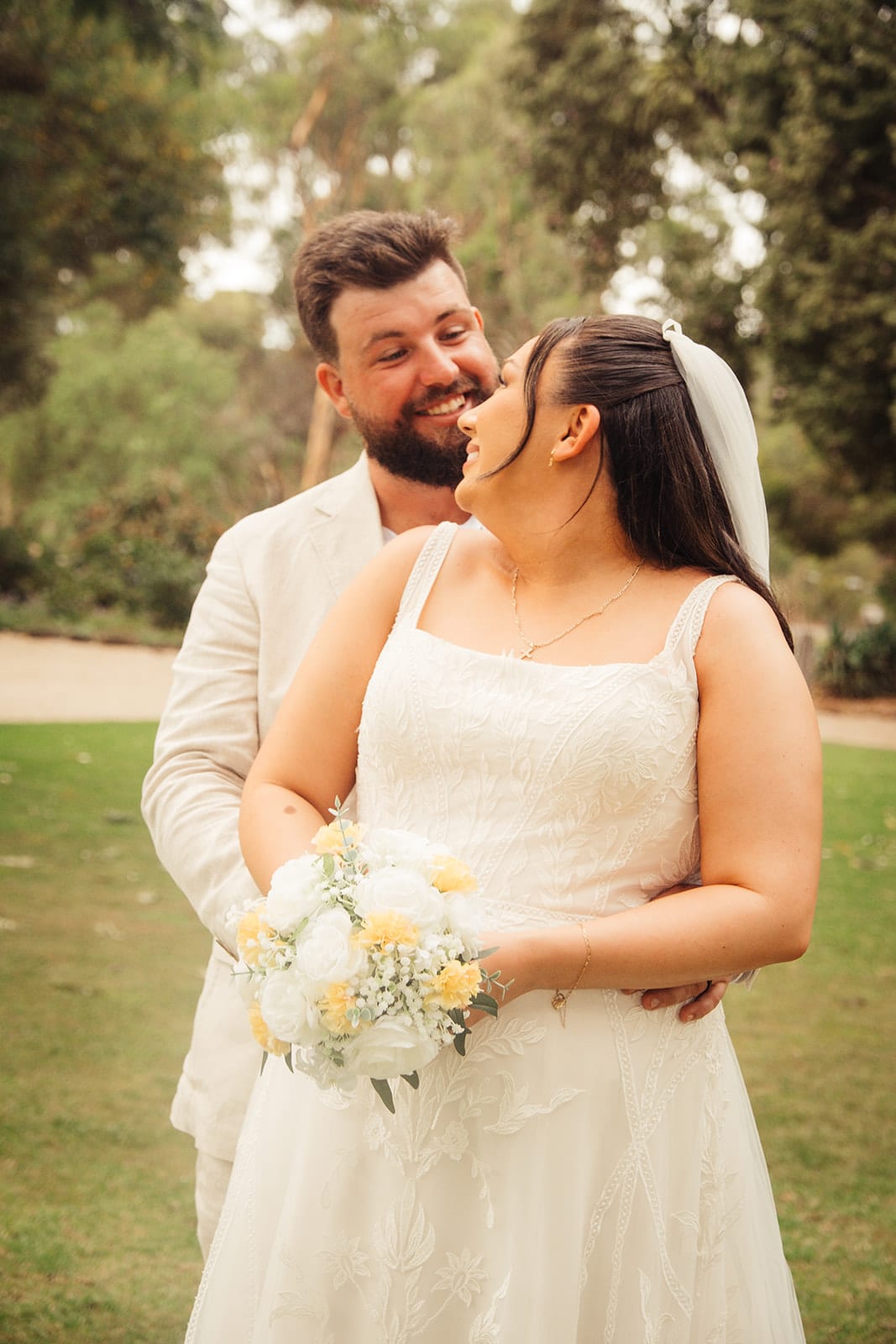 Karina and Bronson close together, smiling, in the garden