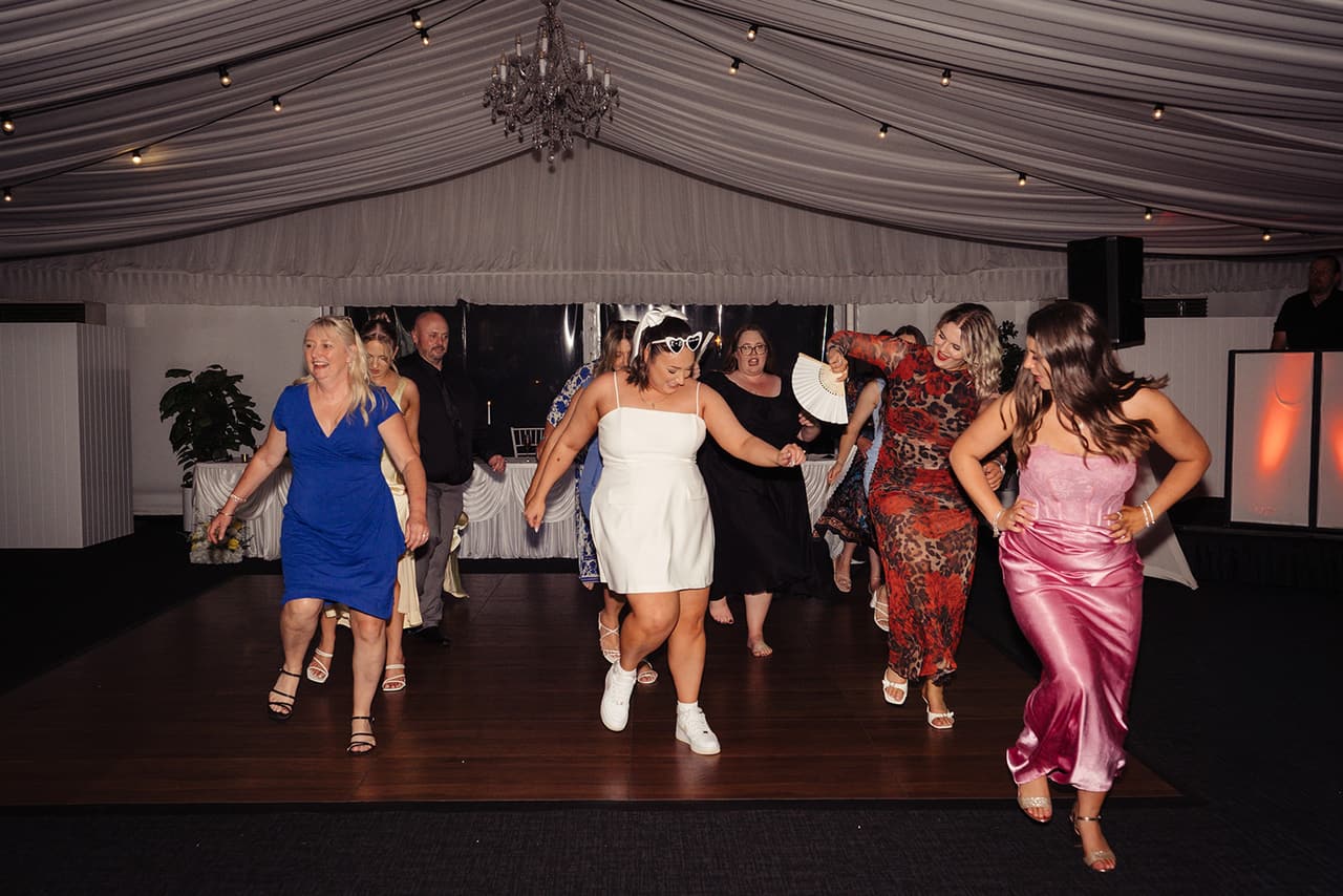 Friends dancing together in a line on the dance floor