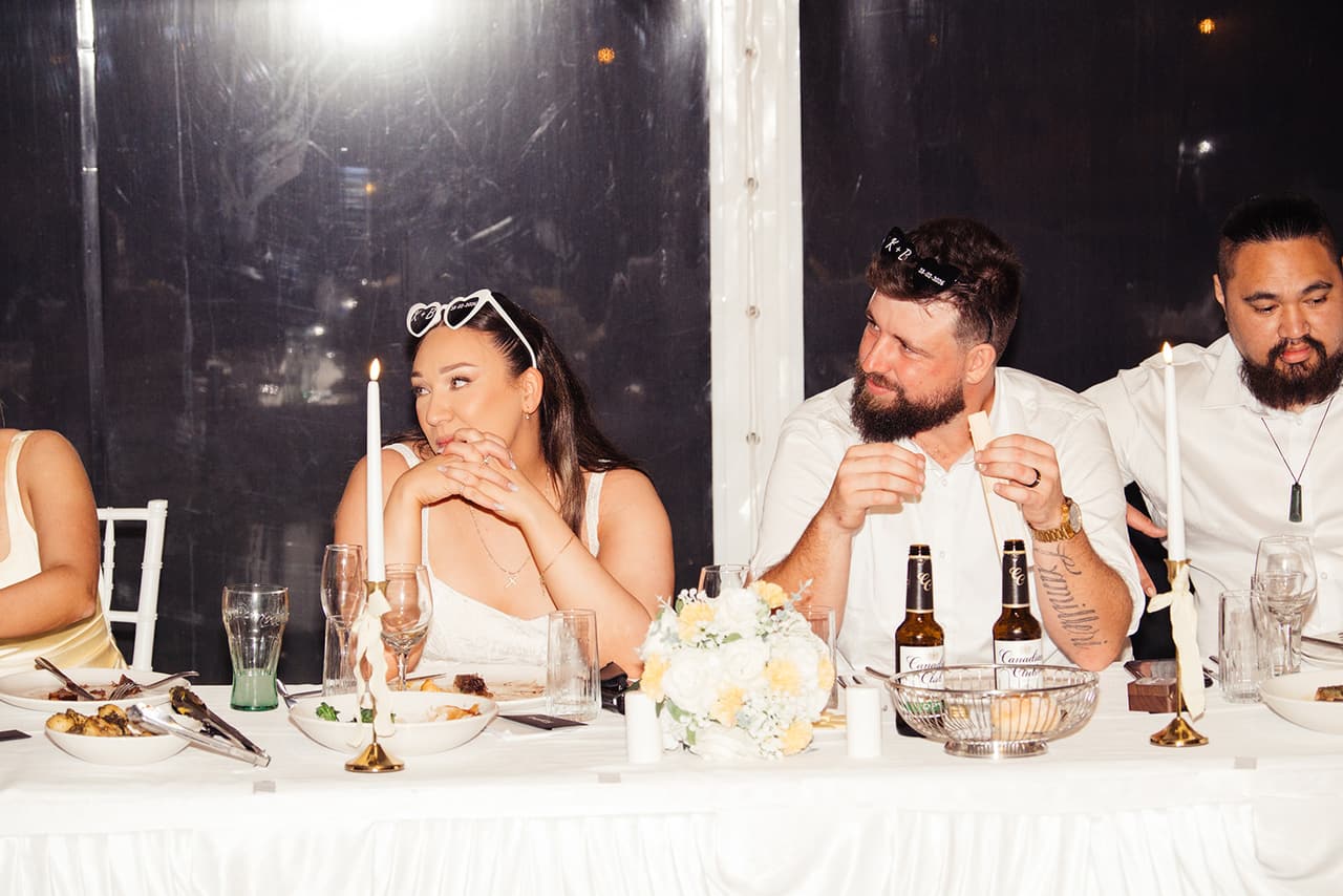 Karina and Bronson at the candlelit head table, her heart sunglasses pushed up on her head
