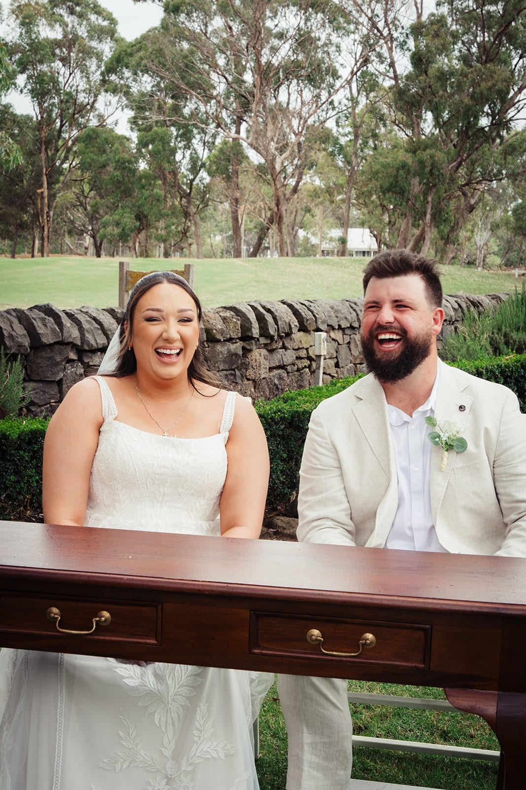 Karina and Bronson smiling at the signing table on the lawn