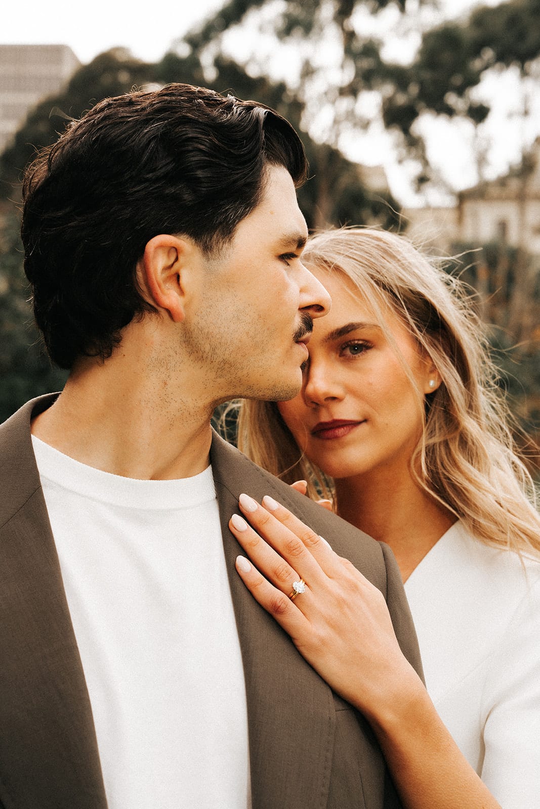 Chris kissing Karina’s forehead, her hand and ring resting on his chest