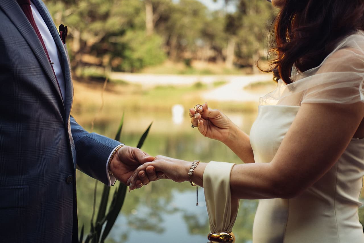 Close up of Kim holding up a ring while Ben holds her other hand
