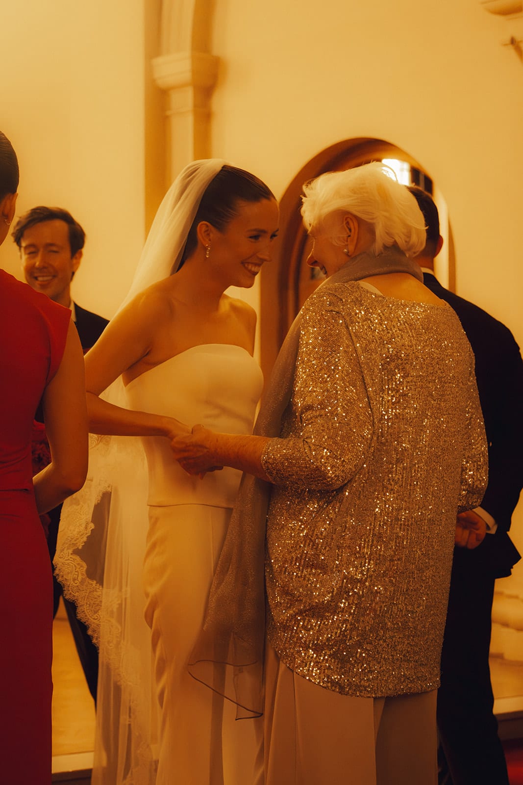 Kira hugging a guest in a sequinned jacket after the ceremony