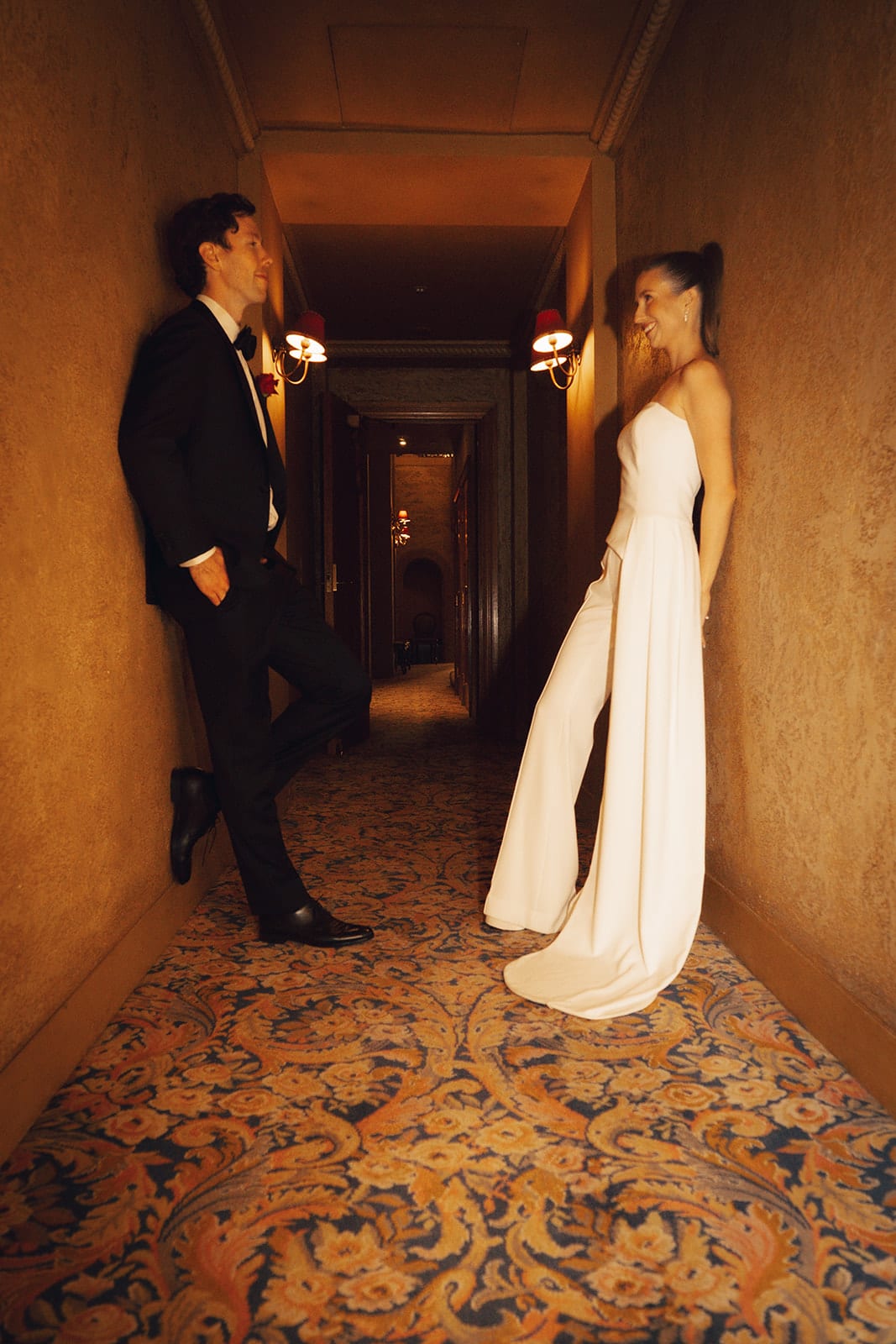 Kira and Nick leaning against the walls of a long carpeted corridor in the Regent Theatre