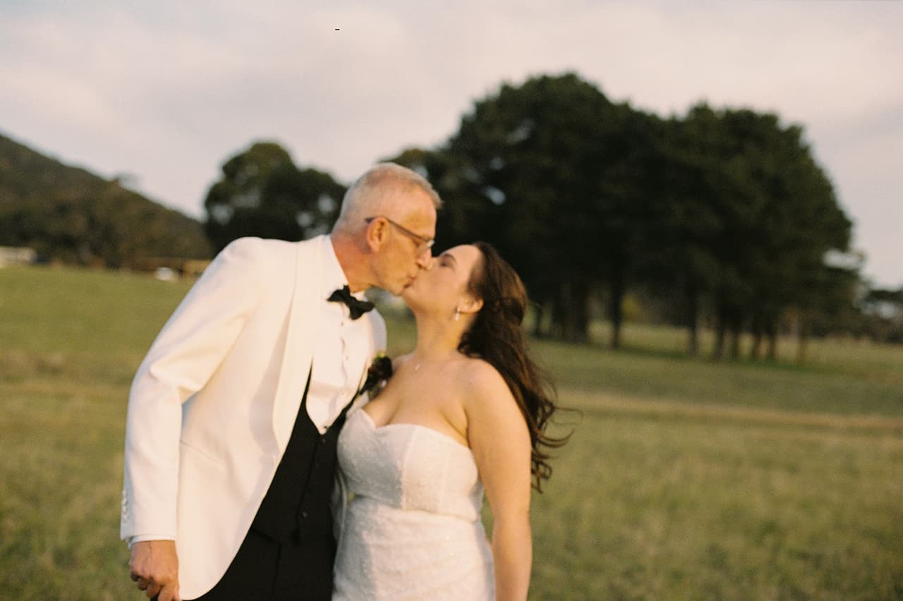 Gareth and Kristie kissing in the paddock in the late afternoon, on 35mm film